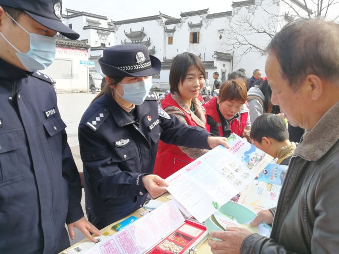 休寧縣公安局民警向現(xiàn)場群眾發(fā)放“防范抵制邪教 共建美好生活”宣傳冊